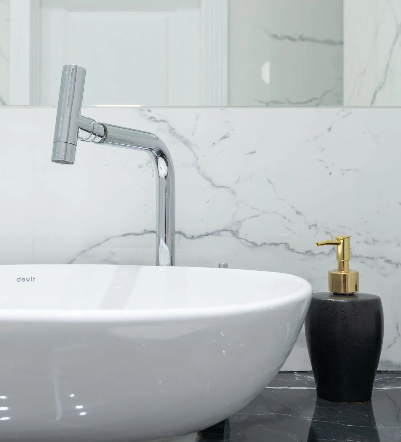 Grifo cromado sobre un lavabo blanco